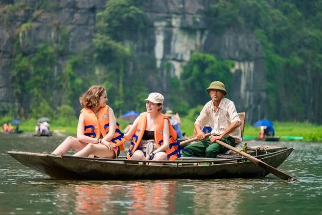 Rowed sampan boat with karst peaks, Trang An, Ninh Binh